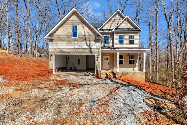 view of front of home featuring a porch and gravel driveway