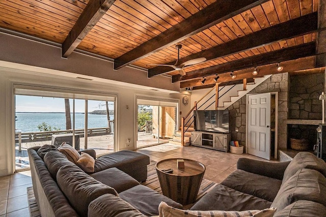 living room featuring light tile patterned floors, wood ceiling, rail lighting, beam ceiling, and a fireplace