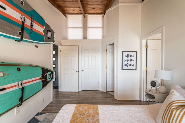 bedroom featuring wood ceiling, dark hardwood / wood-style floors, and a towering ceiling