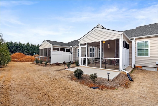 back of house with a sunroom and a yard