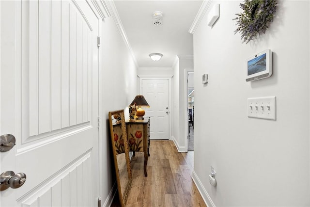 corridor featuring crown molding and light hardwood / wood-style flooring