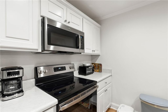 kitchen featuring white cabinetry, crown molding, and stainless steel appliances