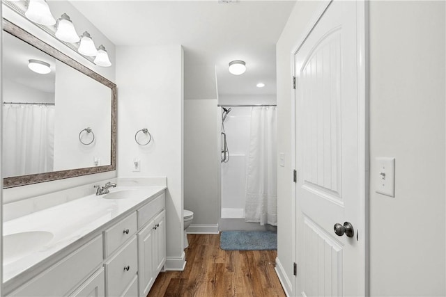 bathroom featuring vanity, hardwood / wood-style flooring, and toilet