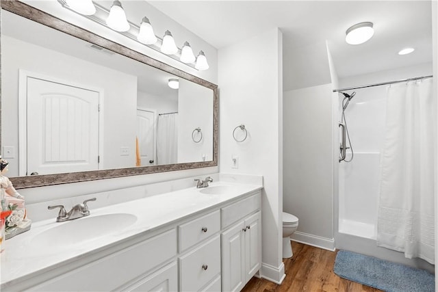 bathroom featuring wood-type flooring, toilet, and vanity