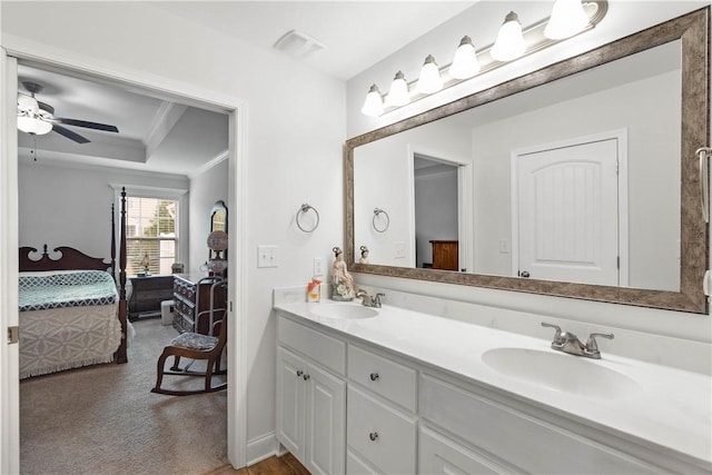 bathroom featuring vanity, crown molding, a raised ceiling, and ceiling fan