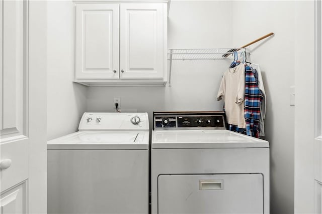 washroom with cabinets and washer and dryer