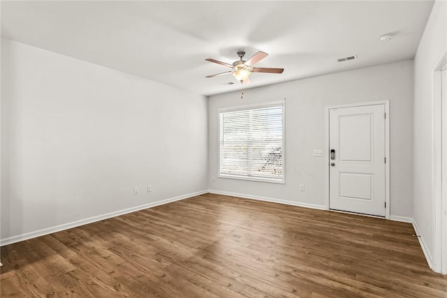 unfurnished room with dark hardwood / wood-style flooring and ceiling fan