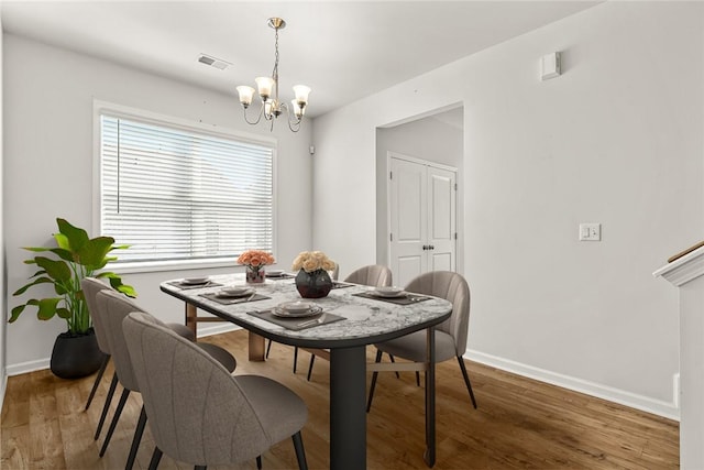 dining room featuring an inviting chandelier and dark hardwood / wood-style flooring