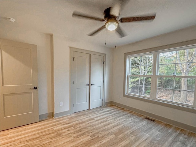 unfurnished bedroom with a closet, ceiling fan, and light hardwood / wood-style flooring