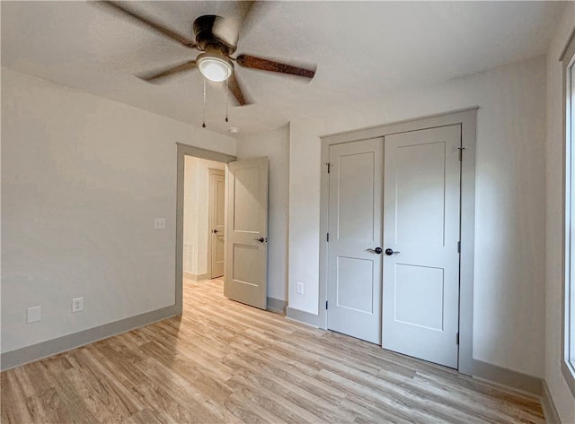 unfurnished bedroom featuring ceiling fan, light wood-type flooring, and a closet