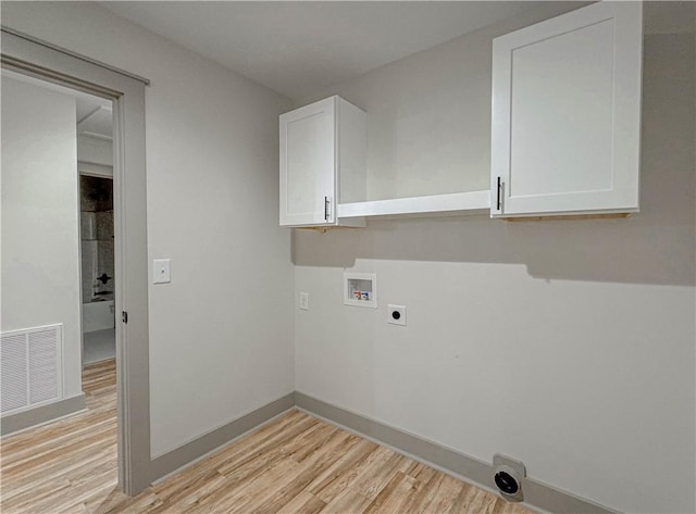 laundry area with electric dryer hookup, washer hookup, light hardwood / wood-style flooring, and cabinets