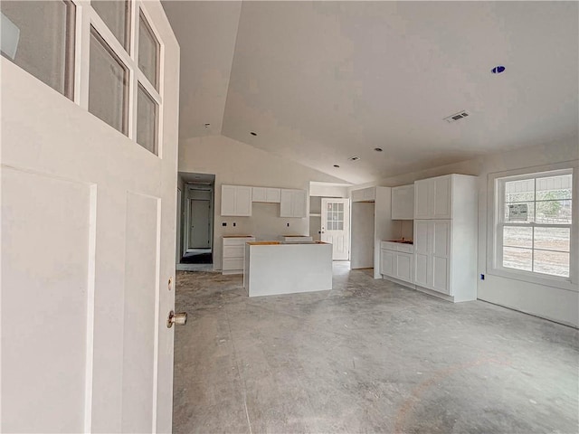 unfurnished living room with high vaulted ceiling