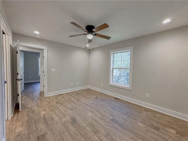 empty room with ceiling fan and light hardwood / wood-style floors