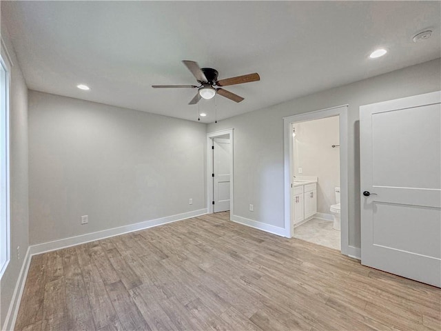 unfurnished bedroom featuring connected bathroom, ceiling fan, and light wood-type flooring