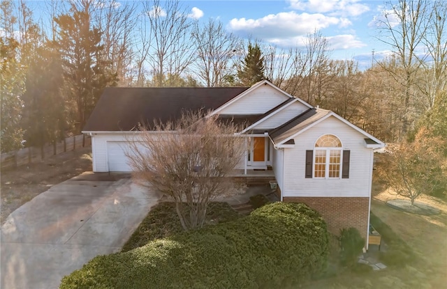 traditional-style house featuring a garage, concrete driveway, and brick siding