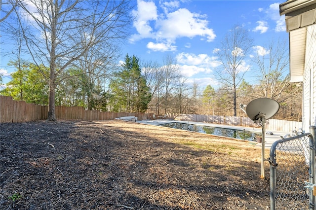 view of yard with a fenced in pool and a water view