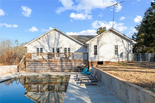 back of house featuring a wooden deck and a patio