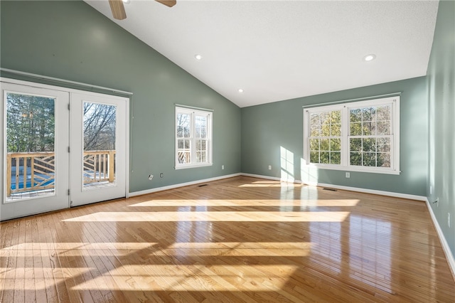 unfurnished living room featuring high vaulted ceiling, recessed lighting, hardwood / wood-style flooring, and baseboards