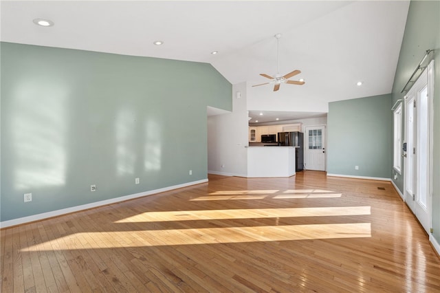 unfurnished living room featuring a ceiling fan, light wood-type flooring, high vaulted ceiling, and baseboards