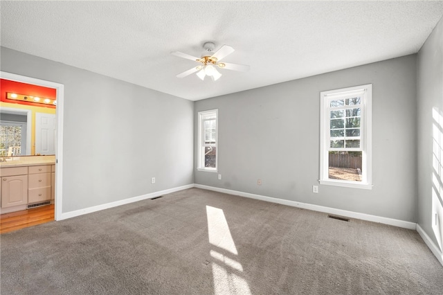 unfurnished bedroom with light carpet, visible vents, baseboards, and a textured ceiling