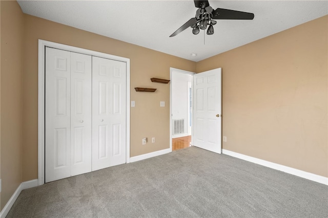 unfurnished bedroom with a closet, carpet flooring, visible vents, and baseboards