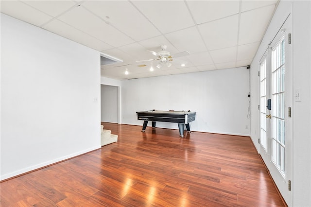 playroom with a paneled ceiling, baseboards, a ceiling fan, and wood finished floors