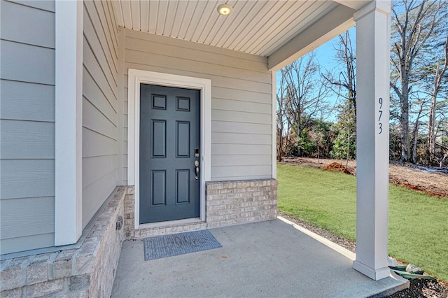 property entrance with a lawn