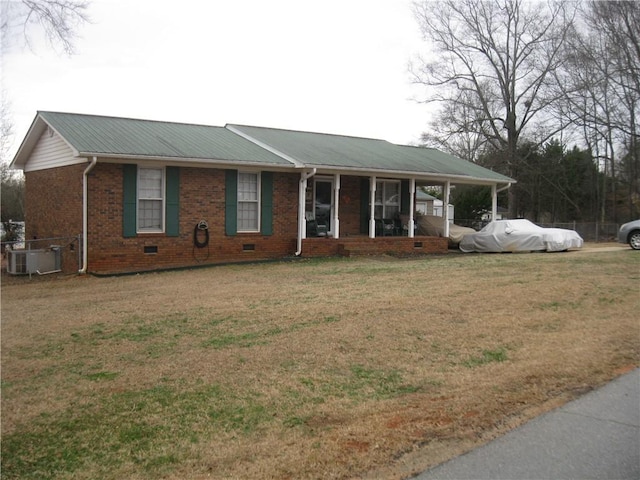 ranch-style home with cooling unit, covered porch, and a front lawn