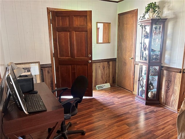 office area with visible vents, wooden walls, and wood finished floors