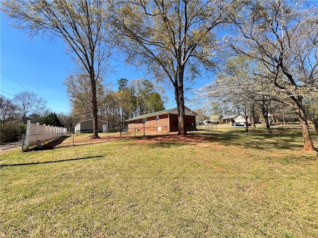 view of yard with an outbuilding, fence, and a pole building