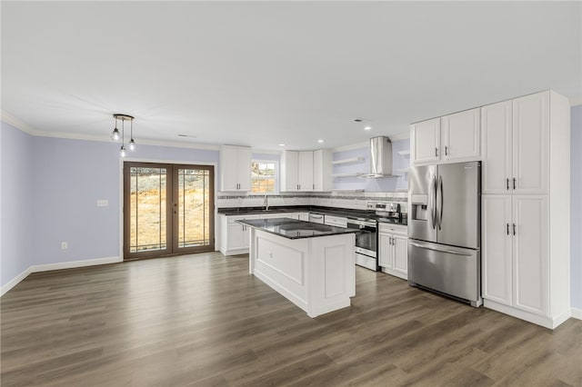 kitchen with white cabinetry, appliances with stainless steel finishes, pendant lighting, and wall chimney range hood