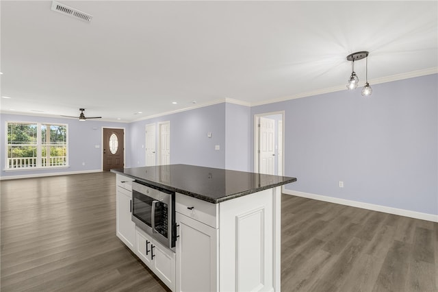 kitchen with crown molding, hanging light fixtures, a center island, wood-type flooring, and white cabinets