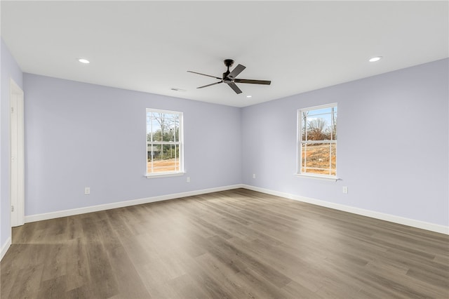 empty room with hardwood / wood-style flooring, a wealth of natural light, and ceiling fan