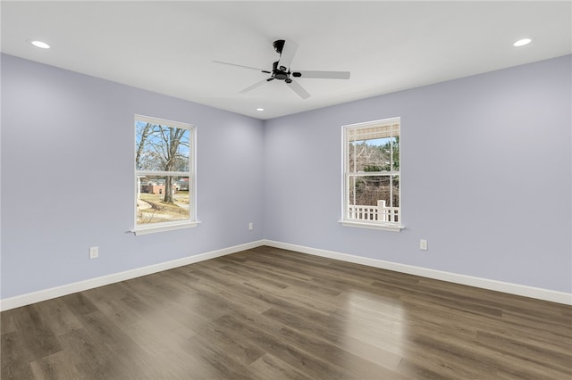 spare room with a healthy amount of sunlight, dark wood-type flooring, and ceiling fan