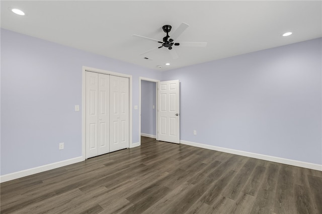 unfurnished bedroom with a closet, dark hardwood / wood-style floors, and ceiling fan