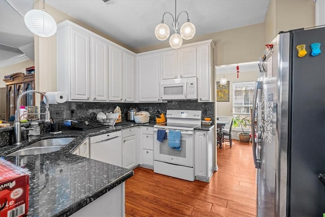 kitchen with decorative light fixtures, sink, white cabinets, decorative backsplash, and white appliances