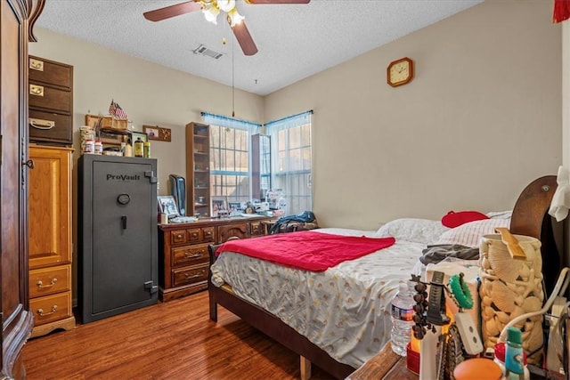 bedroom featuring hardwood / wood-style floors, a textured ceiling, and ceiling fan