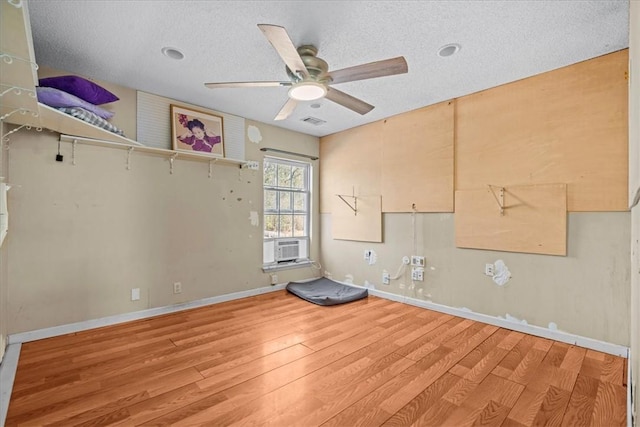 unfurnished room featuring cooling unit, ceiling fan, hardwood / wood-style floors, and a textured ceiling