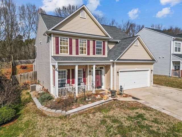 view of property with a garage, a front lawn, and covered porch