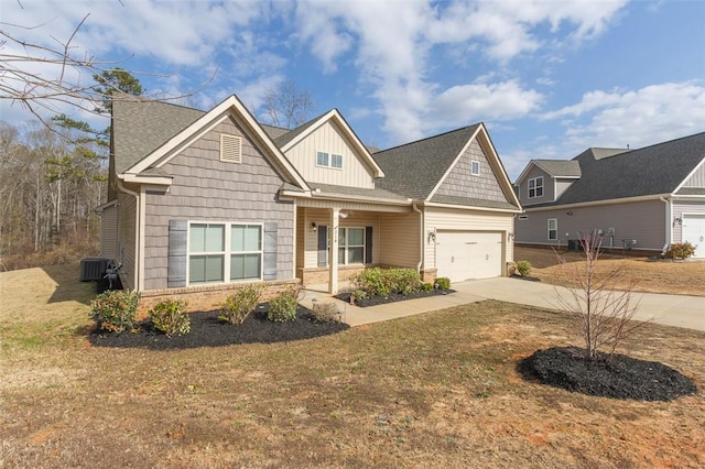 craftsman-style home featuring cooling unit, a garage, a front lawn, and a porch