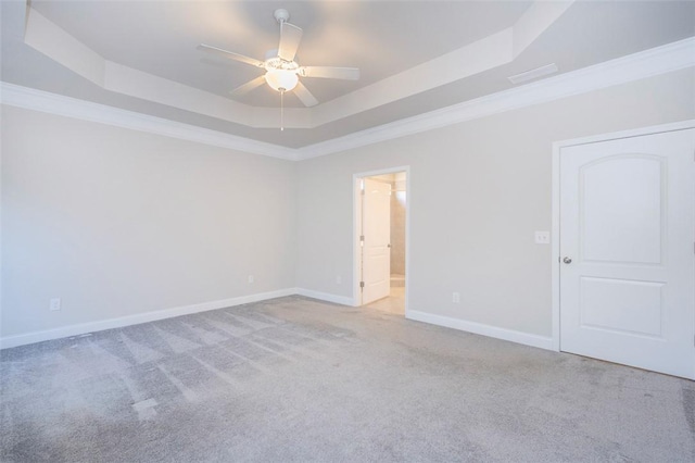 spare room with light carpet, crown molding, a raised ceiling, and ceiling fan