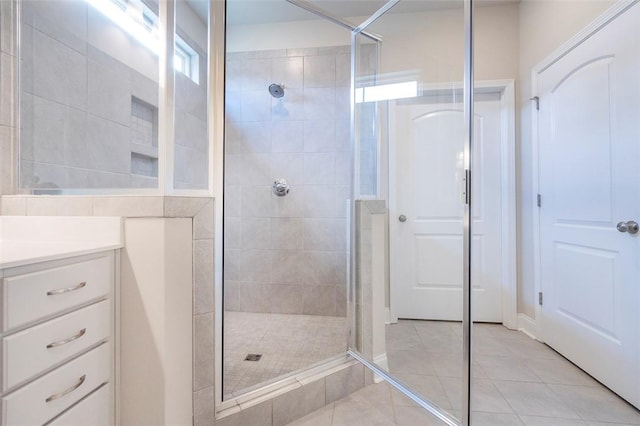 bathroom with tile patterned flooring, vanity, and a shower with shower door