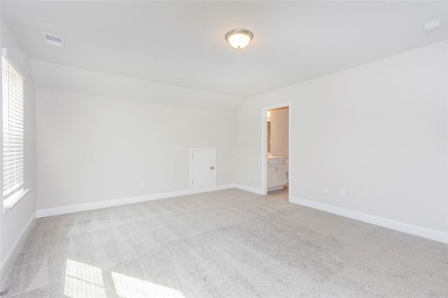 spare room featuring light colored carpet and plenty of natural light