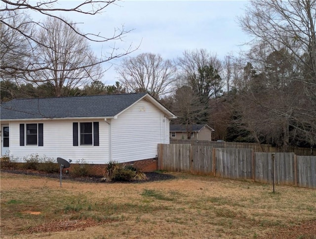 view of side of home with a yard