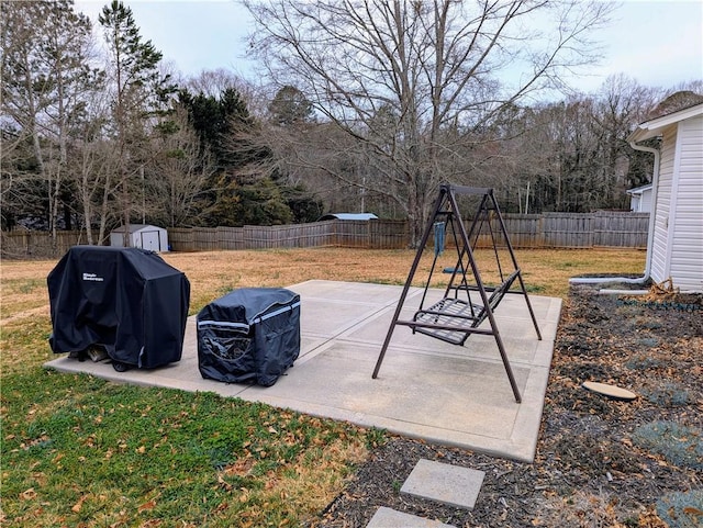 view of patio / terrace with a storage shed, grilling area, and a playground