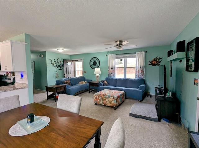 carpeted dining space featuring ceiling fan and a textured ceiling