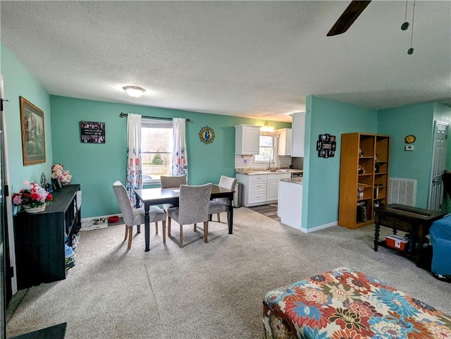 carpeted dining room with a textured ceiling