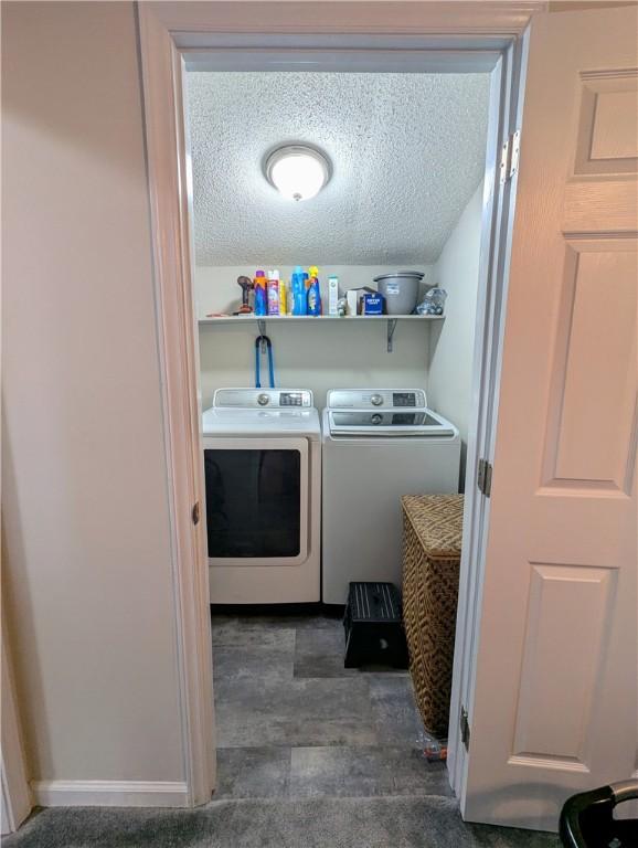 washroom featuring washer and clothes dryer and a textured ceiling