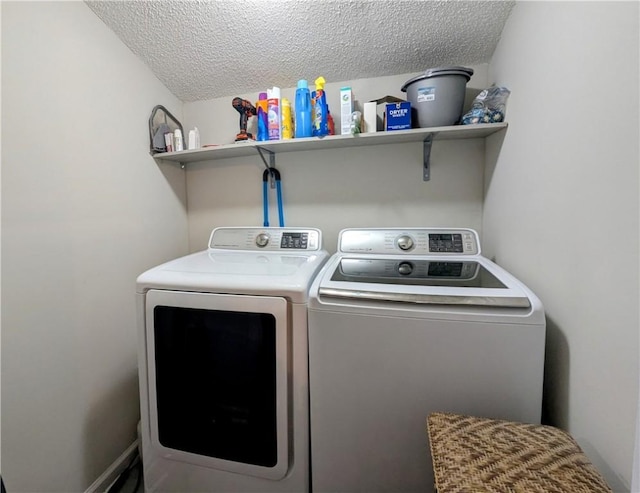 laundry room with a textured ceiling and washer and clothes dryer