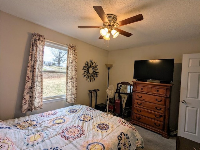 bedroom with ceiling fan, carpet flooring, multiple windows, and a textured ceiling